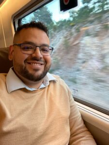 Eduardo Vaquero viajando en tren, sonriente y en movimiento